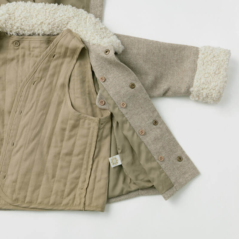 Beige quilted jacket with shearling collar and cuffs on a white background